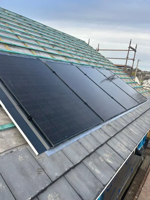 Black solar panels fitted to a tiled roof