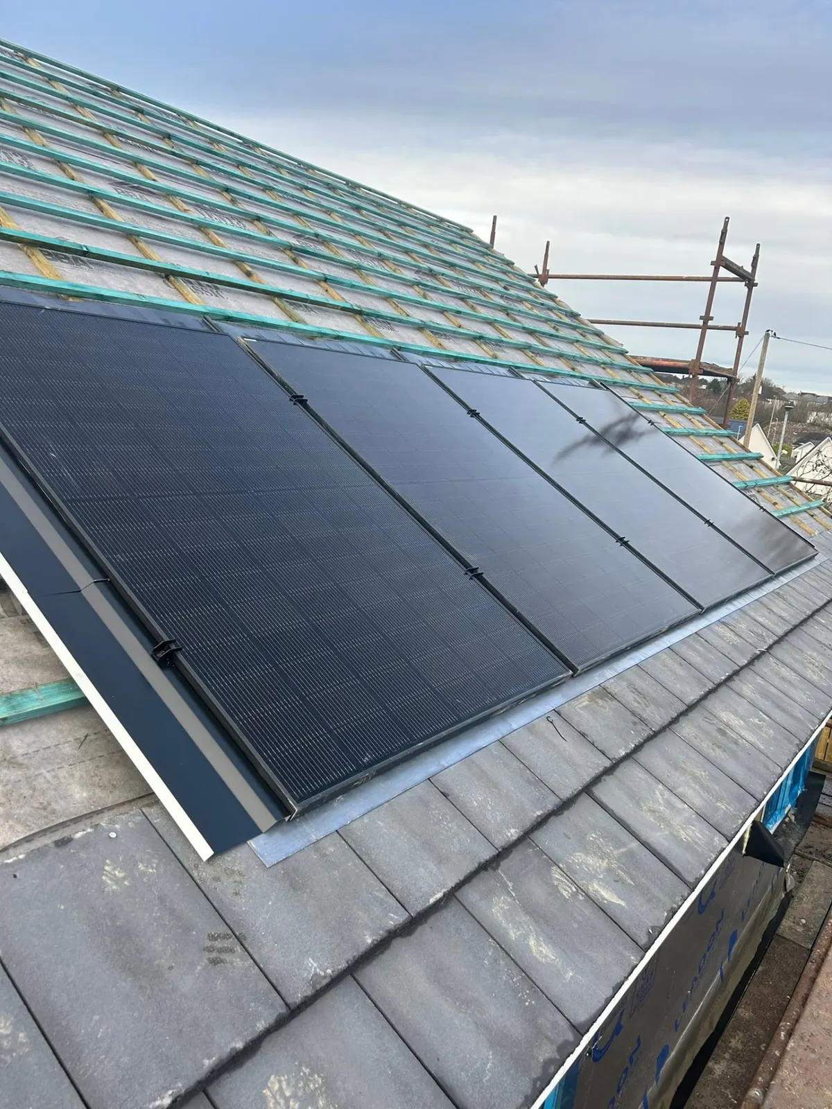 Black solar panels fitted to a tiled roof