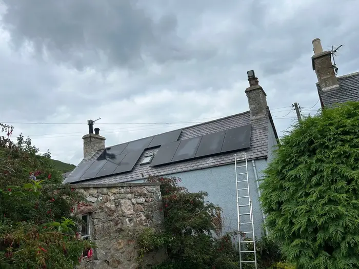 Black solar panels on the roof of a traditional house