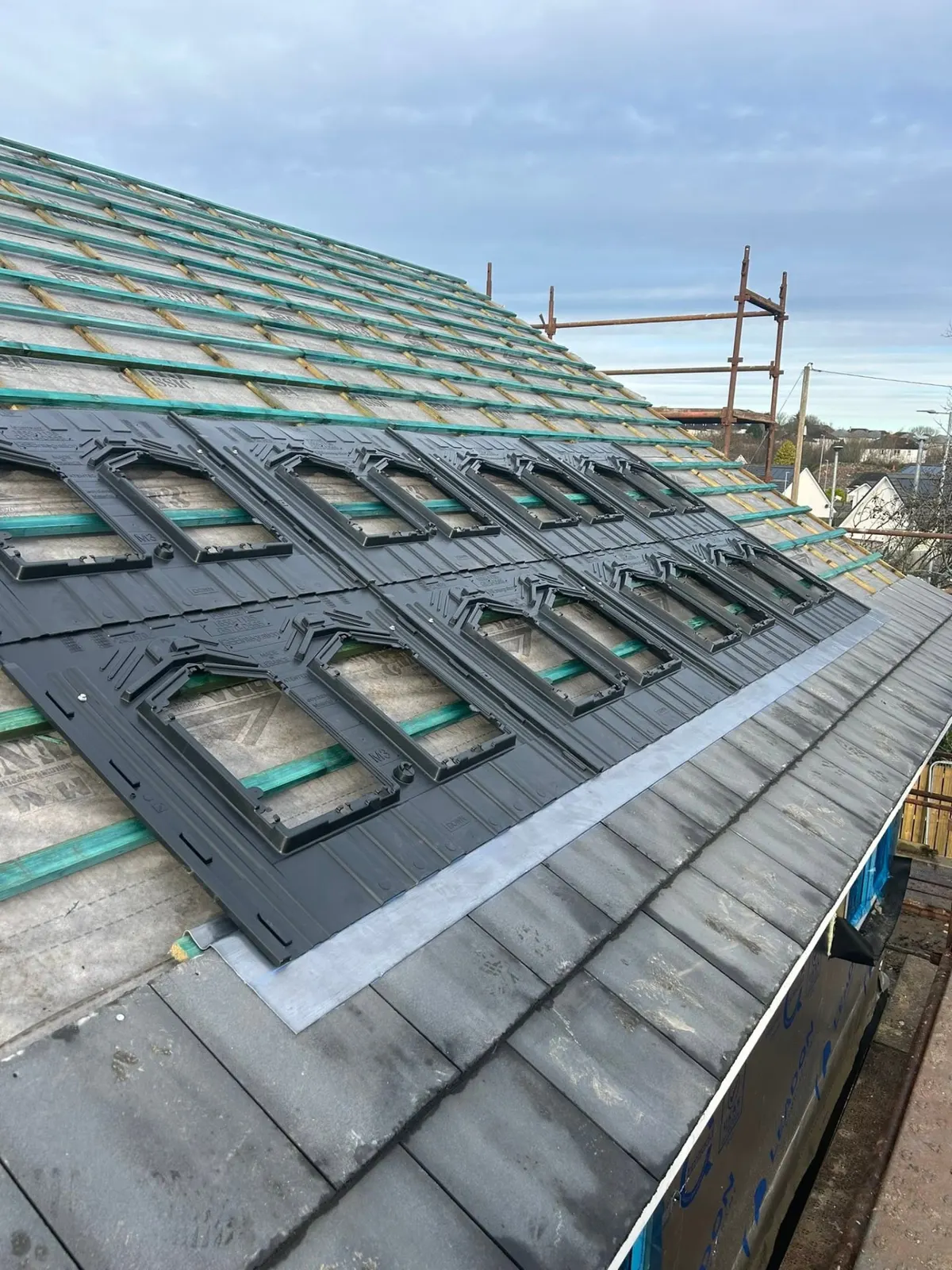 Solar panel installation in progress on a tiled roof